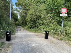 Chaîne de barrière peinte en blanc pour une meilleure visibilité à l'entrée d'un chemin à Vauhallan (91)